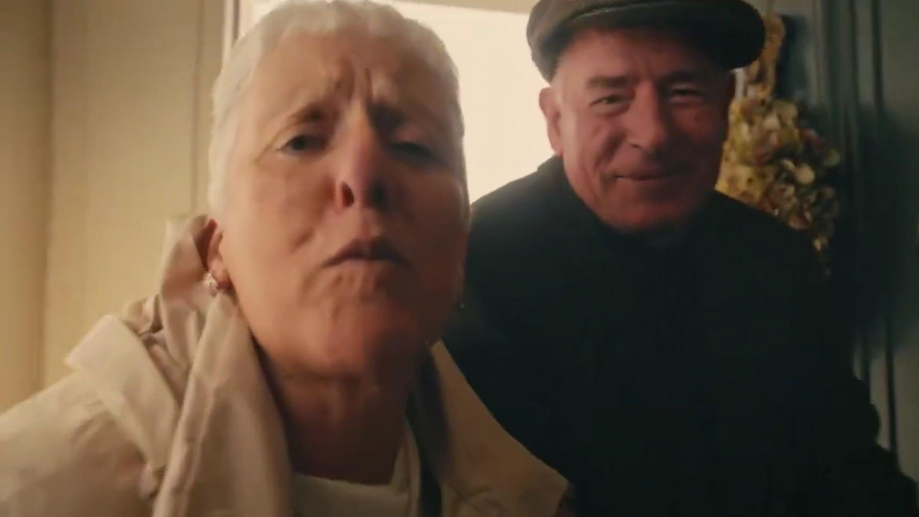 Two elderly people hugging a young boy