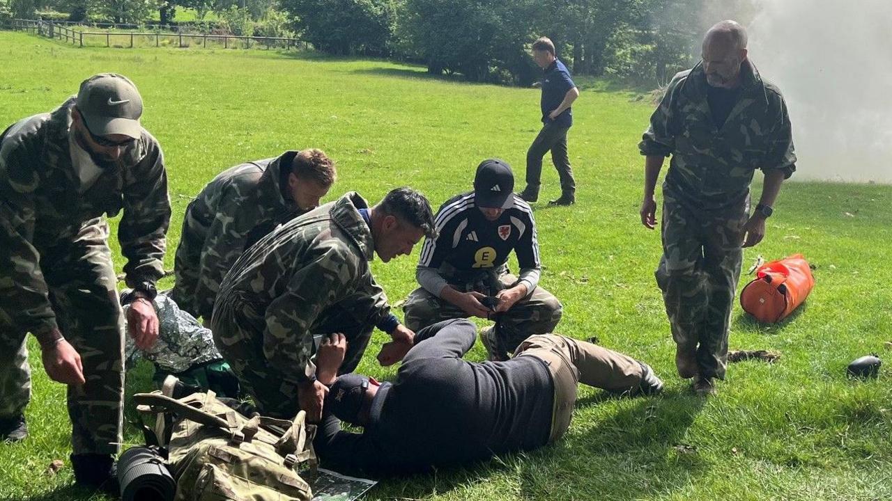 Aaron Ramsey, Willy Caballero and Luke Williams tending to a casualty during the UEFA Pro License course