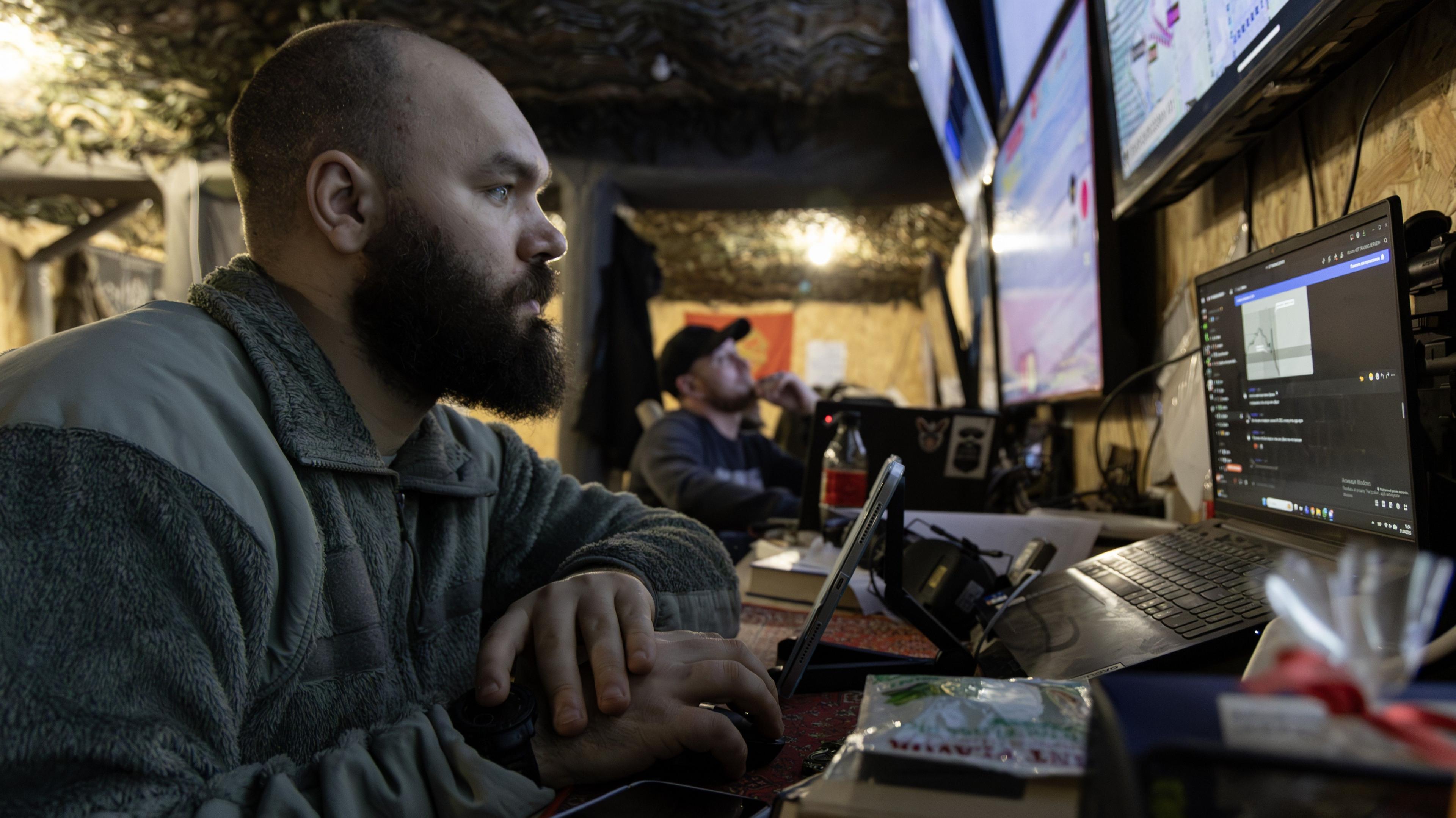 Ukrainian soldier surrounded by computer screens